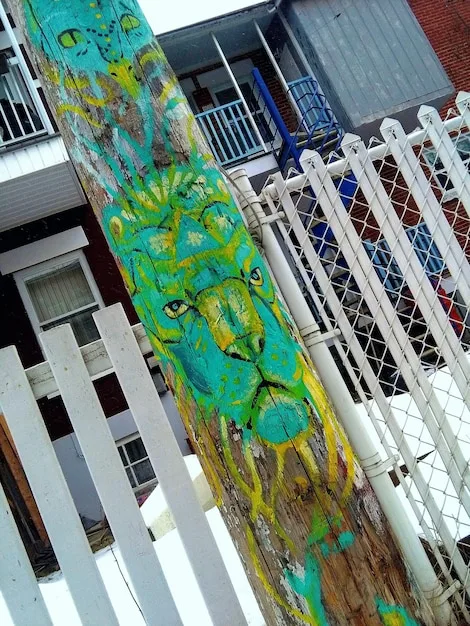 A well-preserved, colorful graffiti mural on a building wall in a bustling city street, looking vibrant and clean, hinting at successful preservation efforts.