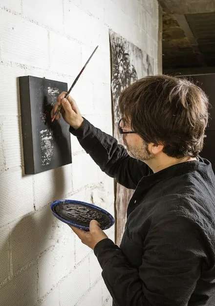 A collector examining an framed canvas graffiti piece in a minimalist gallery setting, highlighting the transition from street to curated spaces, focusing on the quality and framing of the artwork.