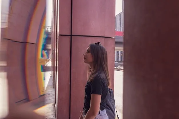 A person in a casual streetwear outfit, wearing a minimalist black backpack with subtle branding, walking down a vibrant city street lined with murals.