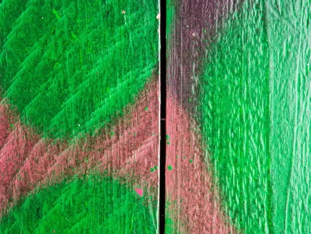 A close-up of a graffiti mural detailing the interaction of red and green spray paint, highlighting texture and layering, with specific small elements in sharp contrast.