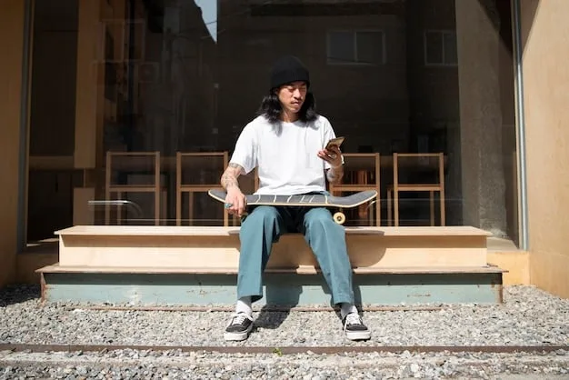 A person wearing an expertly styled oversized streetwear outfit. They have on a large, boxy graphic t-shirt in cream, tucked slightly into high-waisted, relaxed-fit washed black jeans. Their sneakers are chunky and prominent, adding to the balanced proportions. The setting is urban and cool, with concrete textures in the background.