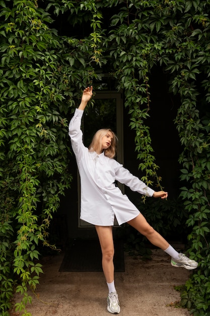 A hip hop dancer poses dynamically while wearing branded athletic apparel, showcasing a natural product integration during a photoshoot.