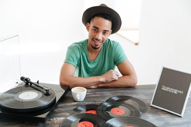 A musician, holding a vinyl record, is sitting in front of a laptop, preparing a digital press kit. The scene highlights the combination of traditional and modern methods used to promote music to college radio stations.
