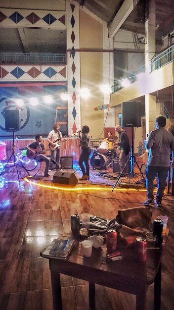 A vibrant scene from a music industry networking event featuring various artists and industry professionals engaged in conversations, exchanging business cards, and listening to music, demonstrating the hustle and opportunities for collaboration.