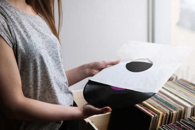 A close-up shot of a person's hands meticulously labeling a stack of vinyl records. The focus is on the detail and care involved in the physical production and distribution of independent music.