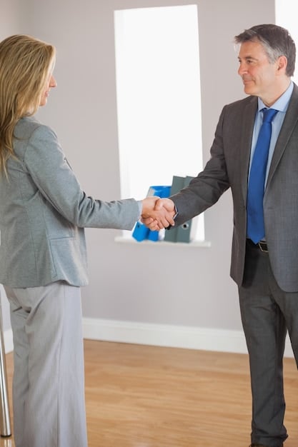 A photo of two people shaking hands over a contract, symbolizing a successful negotiation for sample clearance rights.