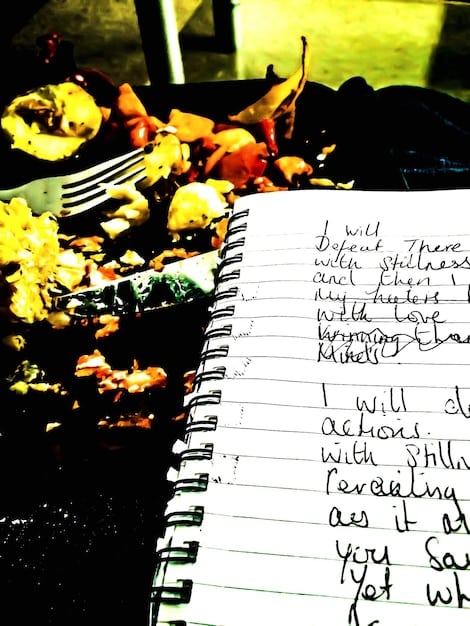 A close-up of a notebook filled with handwritten lyrics, symbolizing the creative process. The lyrics are crossed out and rewritten, showing the struggle and revision involved in artistic creation under censorship pressures.