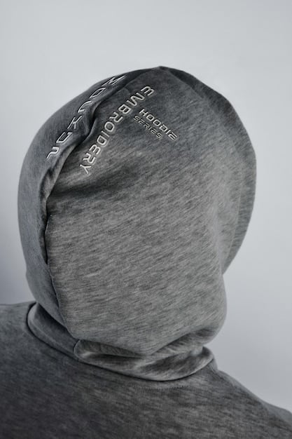 Close-up of a sustainable streetwear hoodie, showcasing the detailed texture of recycled cotton fabric and a minimalist eco-friendly tag.