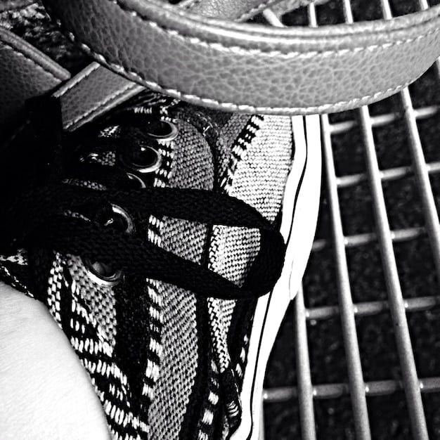 A close-up shot of a limited-edition sneaker, showcasing intricate details, unique stitching, and a collaboration logo, with a blurred urban background.
