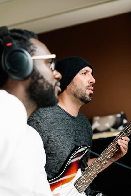 A diverse group of musicians collaborating in a modern recording studio, with one artist looking at a laptop with streaming analytics, reflecting both creative collaboration and data-driven approach.
