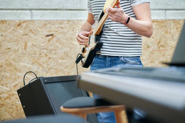 A musician meticulously checking their guitar cables and pedalboard before a performance, highlighting the importance of gear preparation.