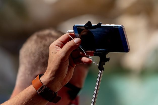 A close-up shot of a smartphone mounted on a compact gimbal stabilizer, filming an artist performing in a dimly lit, atmospheric studio. The focus is on the technology being used to achieve a cinematic look.