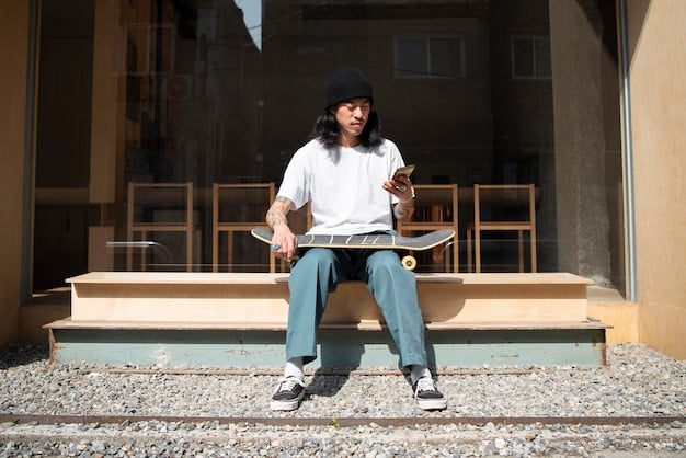 A person wearing an expertly styled oversized streetwear outfit. They have on a large, boxy graphic t-shirt in cream, tucked slightly into high-waisted, relaxed-fit washed black jeans. Their sneakers are chunky and prominent, adding to the balanced proportions. The setting is urban and cool, with concrete textures in the background.